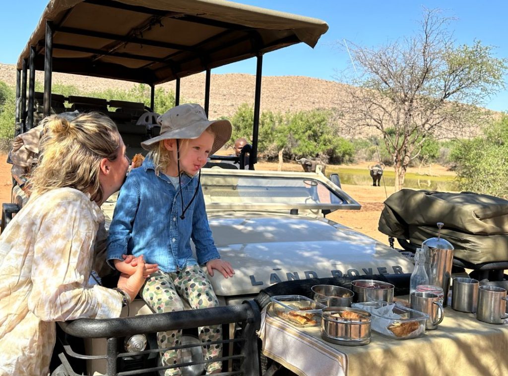 Safari guide explaining safety to a family before a game drive in Tanzania