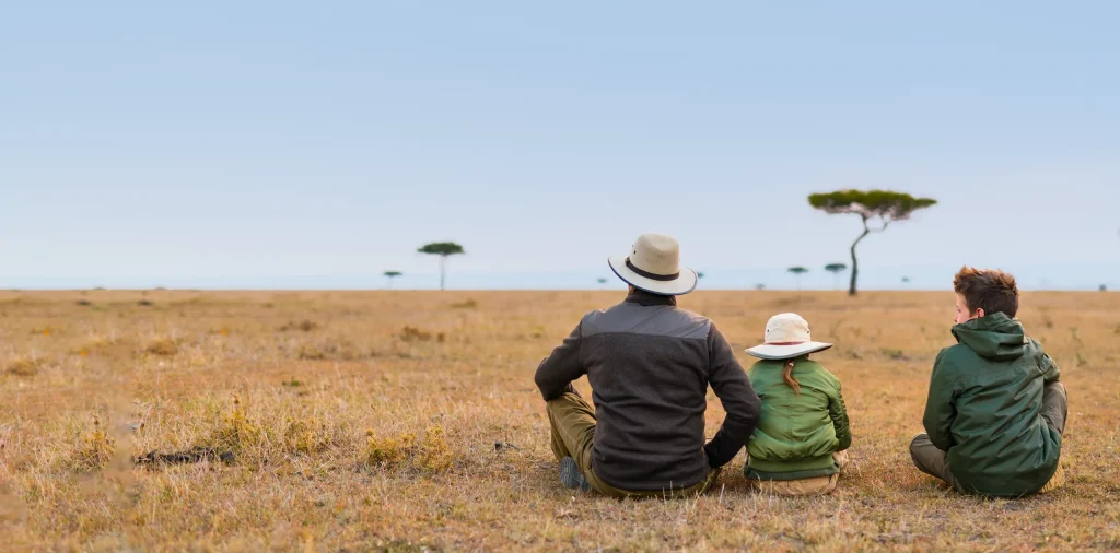Family watching sunset together on safari in Tanzania